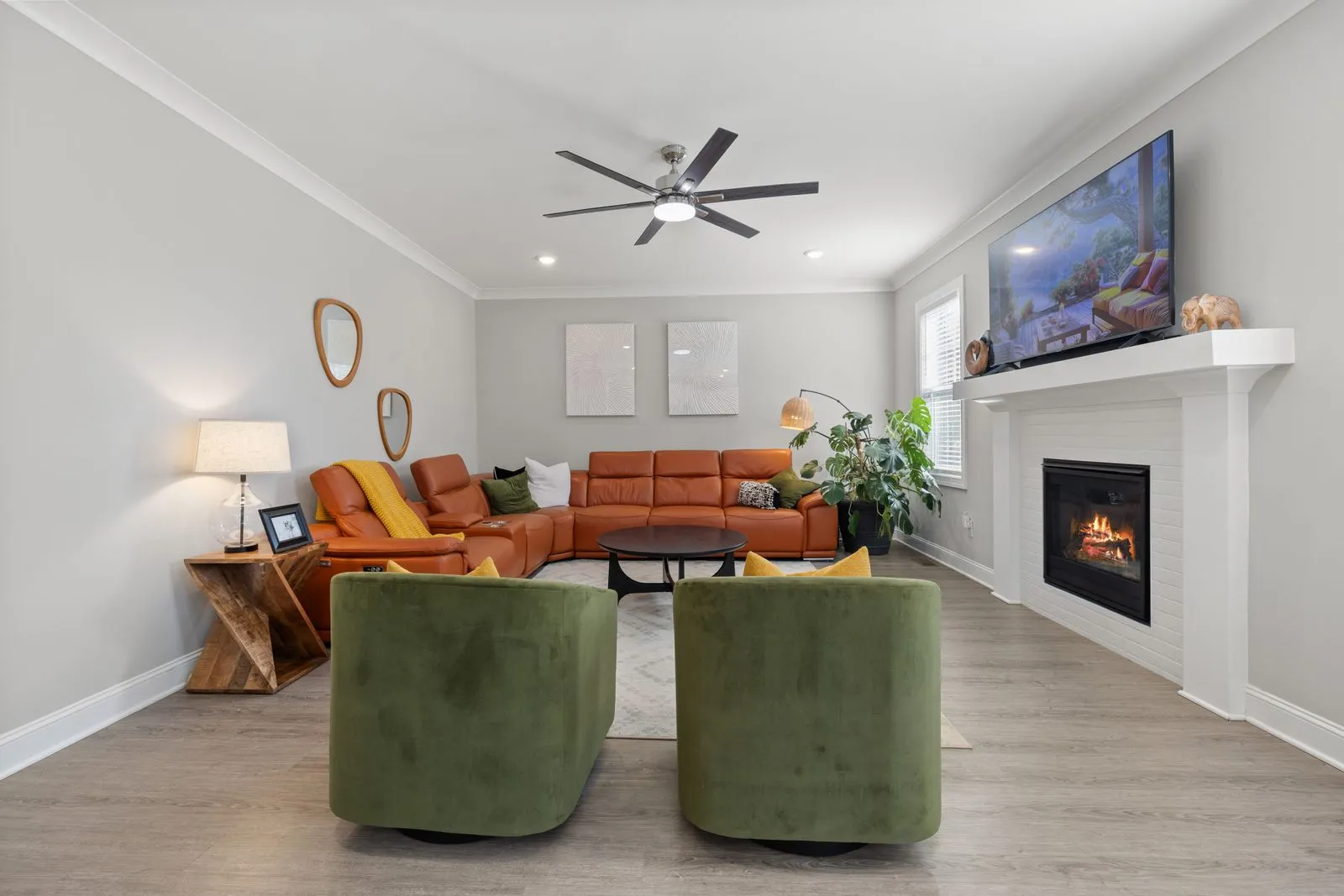 Cozy living room featuring a stylish fireplace, large TV, and plush seating for a relaxed atmosphere.